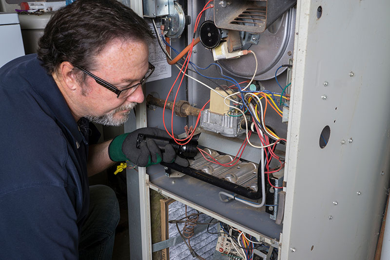 HVAC technician inspecting HVAC unit.