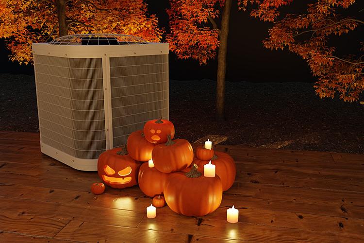 Air conditioning unit with carved pumpkins and candles beside it.