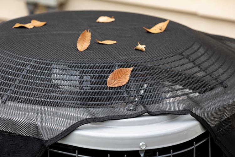 Air conditioning unit with fall leaves on it.