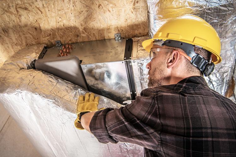 HVAC Technician installing an air duct