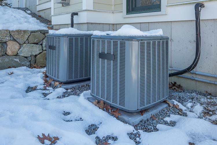 Heat and AC units with snow around them.