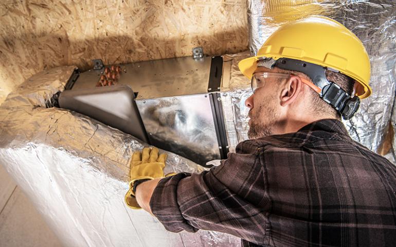 HVAC Technician installing an air duct