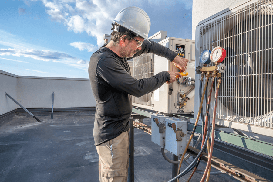 Technician Fixing HVAC Unit on a Commercial Roof