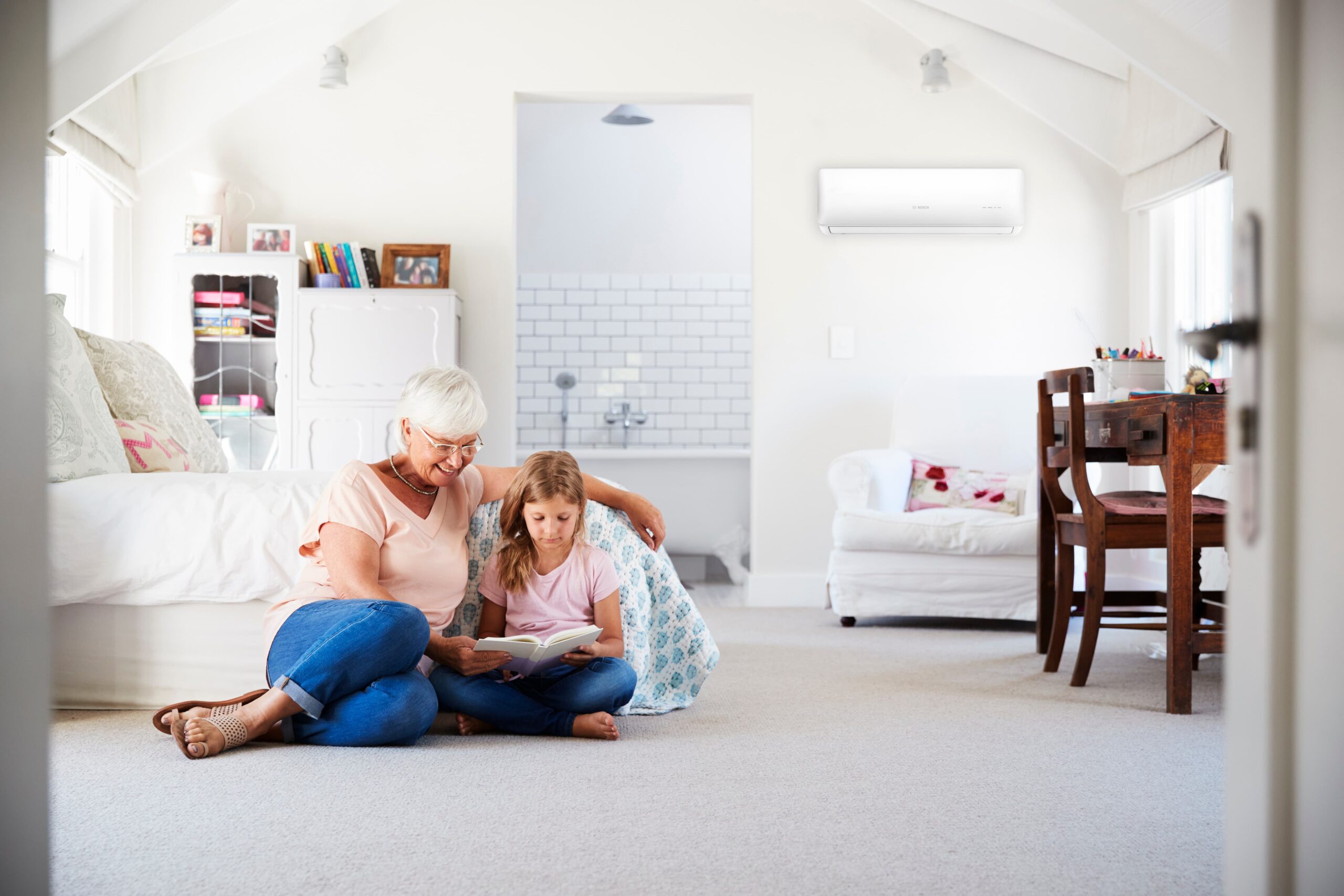 Grandmother and Granddaughter reading together in a comfortable bedroom